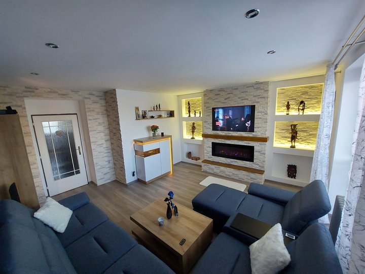 Obývací pokoj s TV stěnou a nepřímým osvětlením