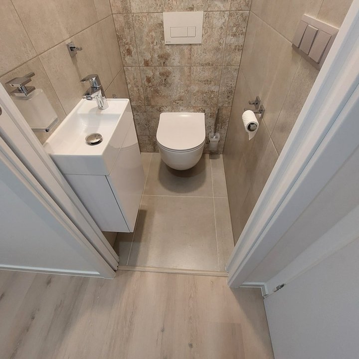 WC s umyvadlem a dřevodekorovým obkladem