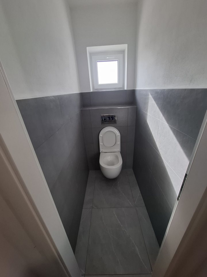 Minimalistická koupelna se šedým obkladem