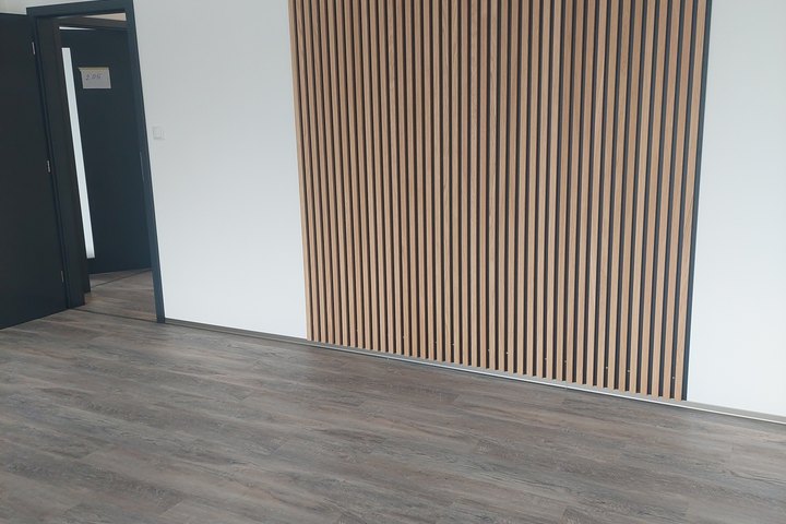 Kancelář s dřevěnou lamelovou stěnou a vinylovou podlahou